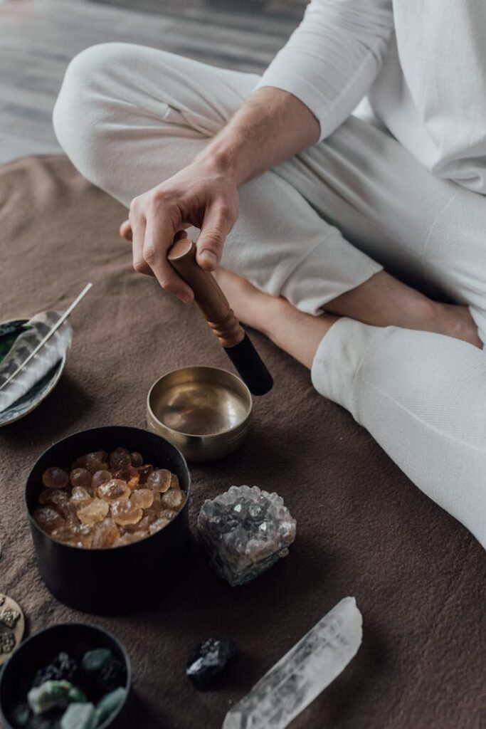 A Person Sitting on the Floor Using a Tibetan Singing Bowl